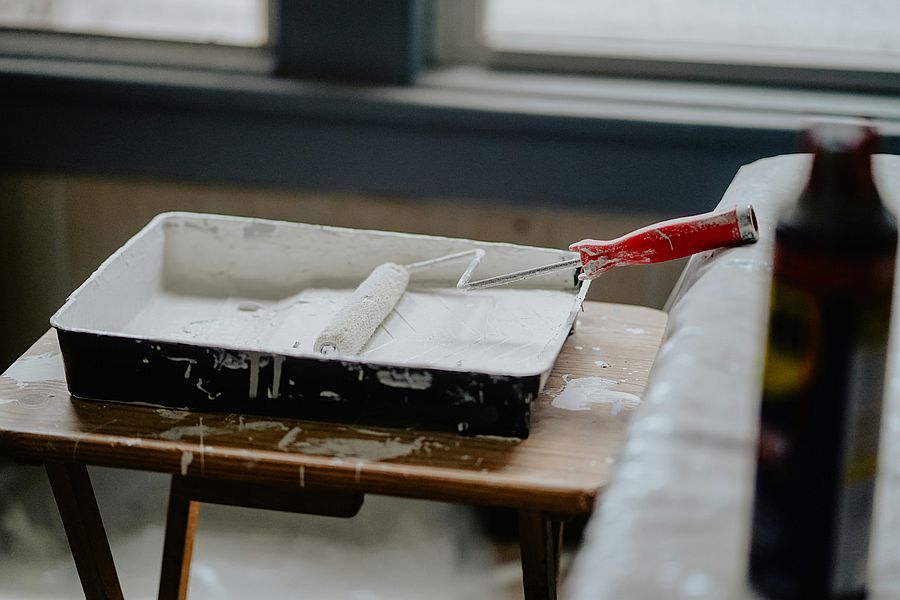 a paint roller and tray on a table