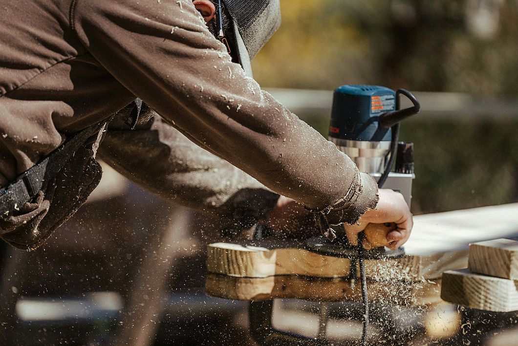 a person using a machine to cut a piece of wood