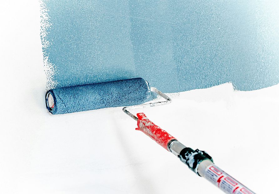 Picture of a paint roller painting a wall.